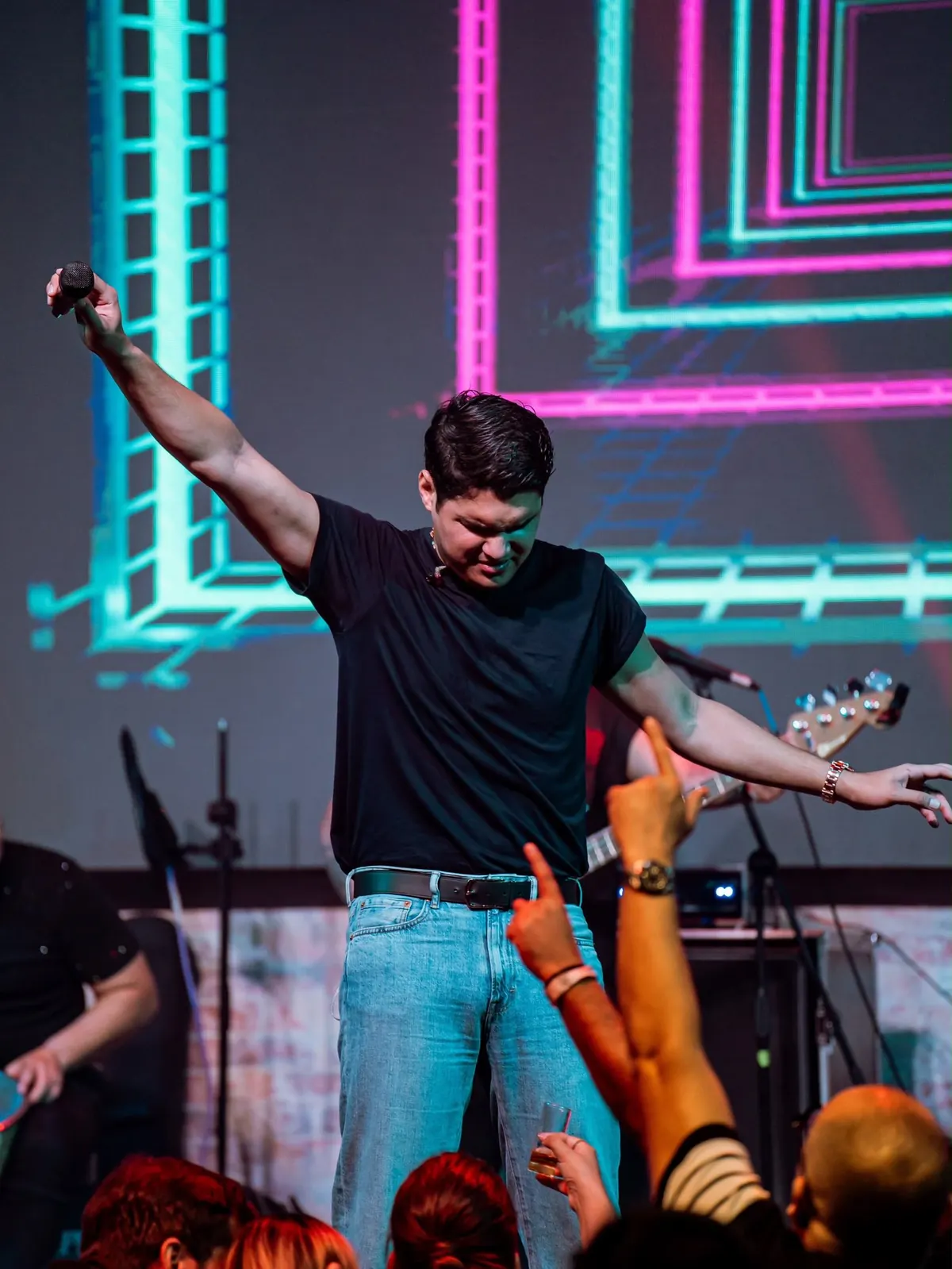 Elder Dayan con el brazo extendido bajo luces de neón
